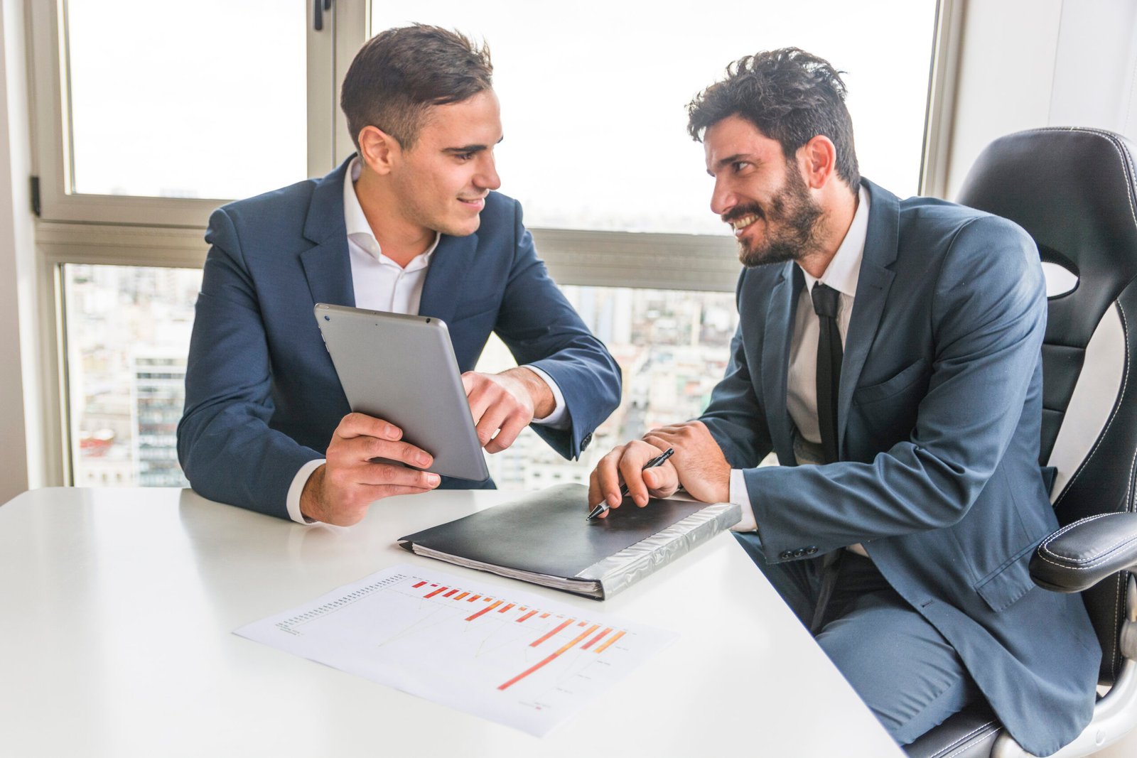 male-employee-showing-his-partner-digital-tablet-meeting